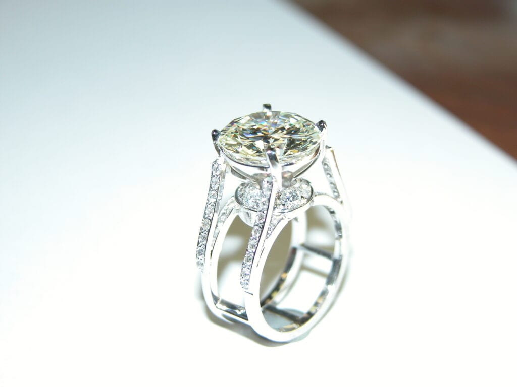 A diamond ring with a large center stone and smaller stones.