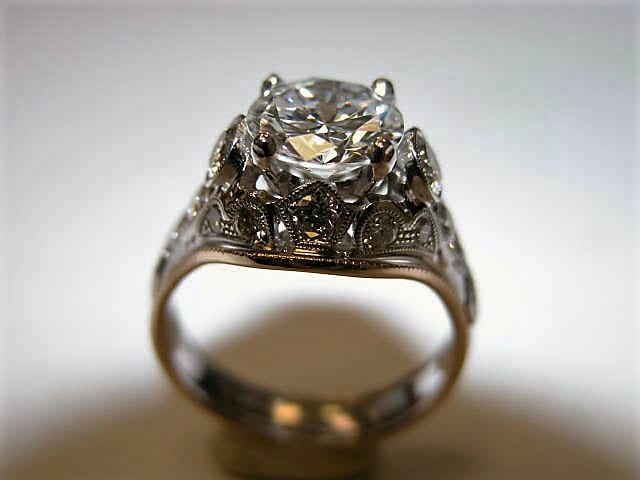 A diamond ring is shown with the center stone in focus.
